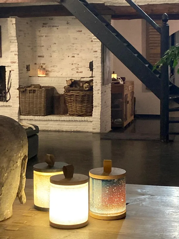 De open haard met manden hout, vooraan lampjes op tafel.