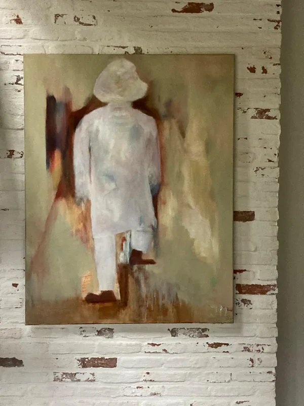 Een witte figuur op een witte bakstenen muur.